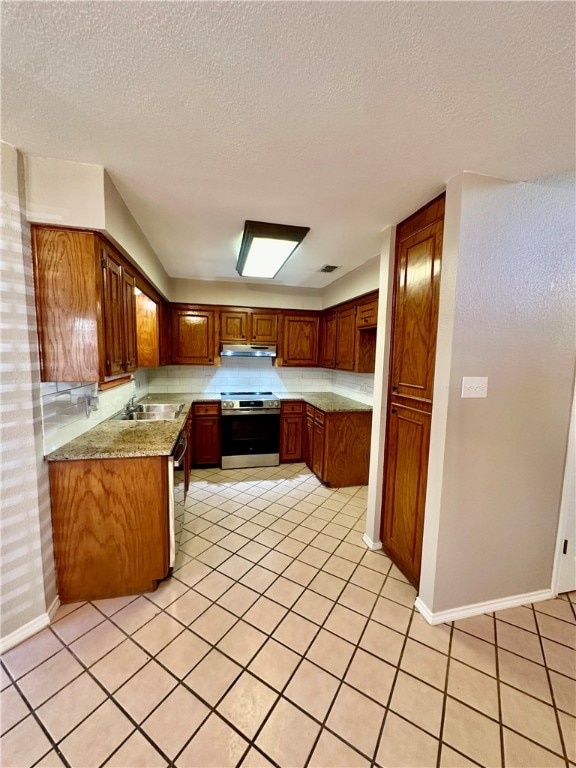 kitchen with stainless steel appliances, light tile patterned flooring, a textured ceiling, and sink