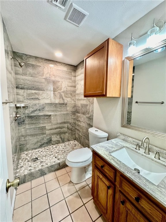 bathroom featuring vanity, a textured ceiling, tile patterned floors, and toilet