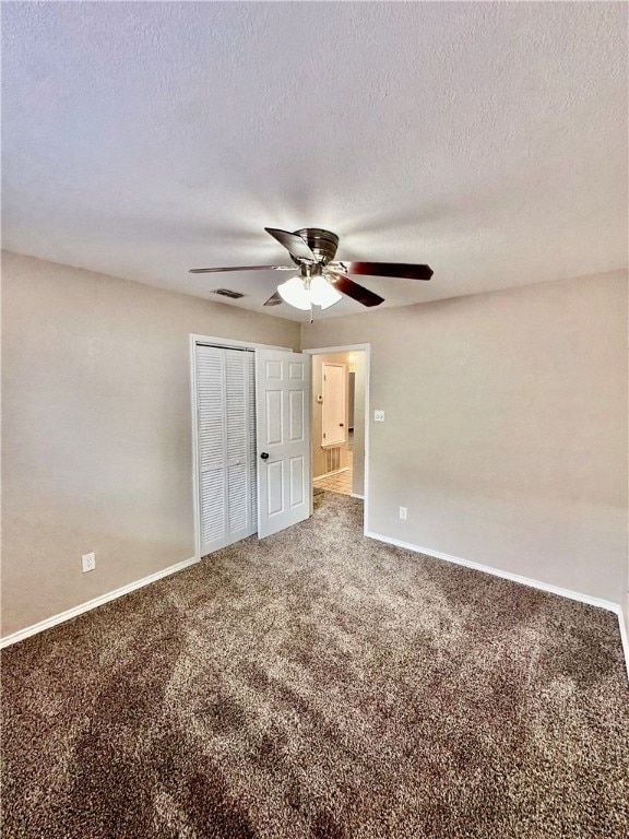 unfurnished bedroom featuring a textured ceiling, carpet flooring, and ceiling fan