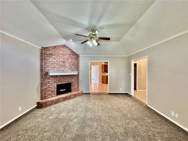 unfurnished living room featuring a brick fireplace, lofted ceiling, carpet floors, ceiling fan, and crown molding