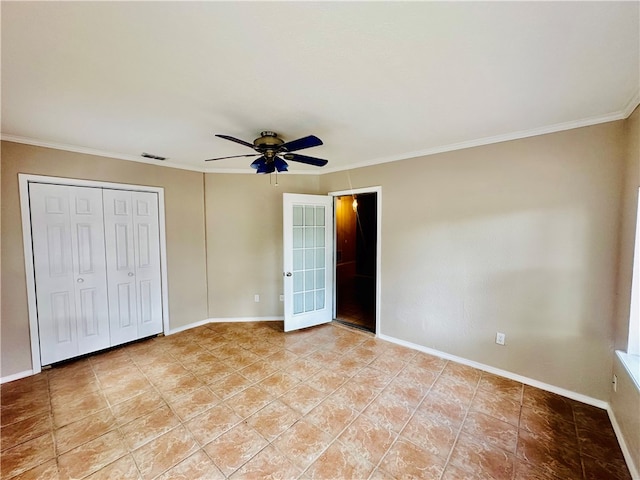 unfurnished bedroom featuring light tile patterned floors, ceiling fan, crown molding, and a closet