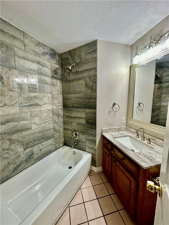 bathroom featuring vanity, tiled shower / bath, a textured ceiling, and tile patterned flooring