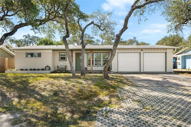 ranch-style home featuring brick siding, an attached garage, and concrete driveway