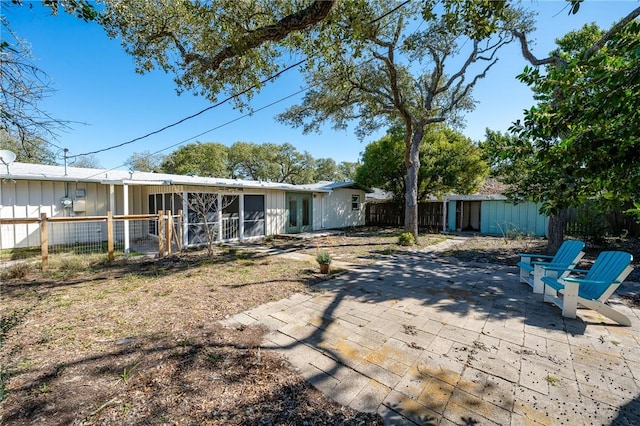 rear view of house with a patio area, fence, and a sunroom