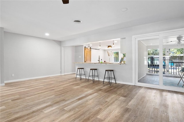 unfurnished living room featuring visible vents, baseboards, recessed lighting, light wood-style floors, and a ceiling fan