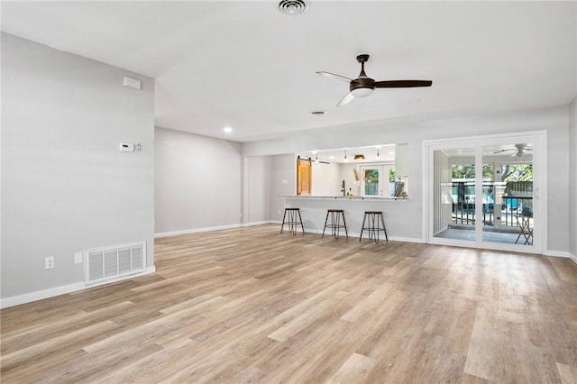 unfurnished living room with visible vents, baseboards, light wood-style flooring, and a ceiling fan