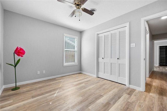 unfurnished bedroom with a closet, ceiling fan, baseboards, and wood finished floors