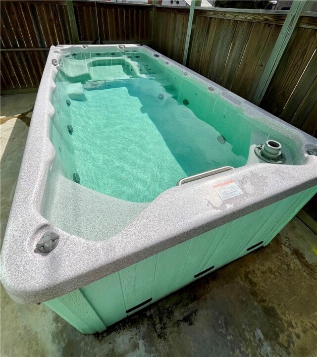 view of swimming pool featuring a hot tub