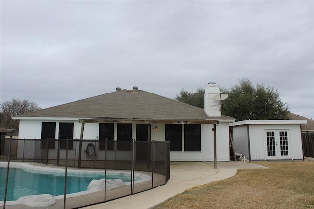 back of house featuring a patio area, french doors, and a lawn