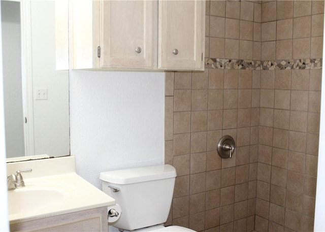 bathroom featuring vanity, tiled shower, and toilet