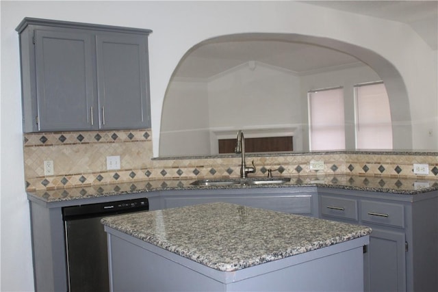 kitchen featuring sink, gray cabinets, dishwasher, a kitchen island, and dark stone counters