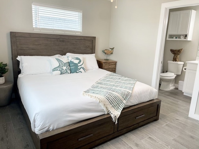 bedroom with light hardwood / wood-style floors and ensuite bathroom