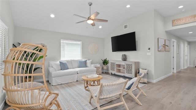 living room featuring vaulted ceiling, ceiling fan, and light hardwood / wood-style flooring