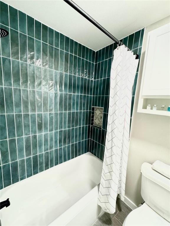 bathroom featuring shower / bath combo with shower curtain and toilet