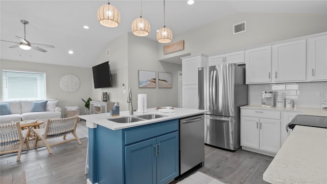 kitchen featuring white cabinetry, stainless steel appliances, a kitchen island with sink, and blue cabinetry