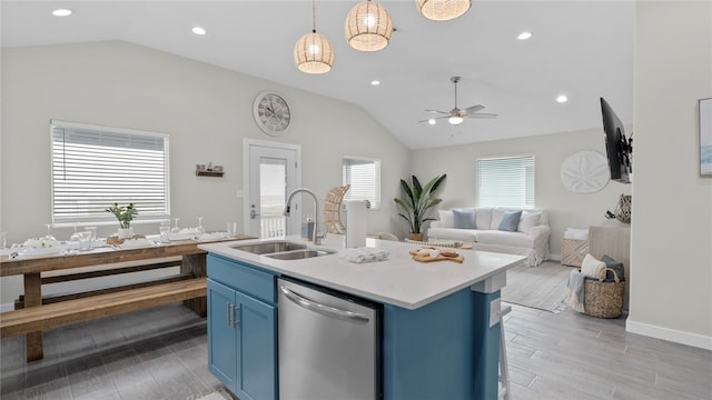 kitchen featuring blue cabinets, dishwasher, plenty of natural light, sink, and an island with sink