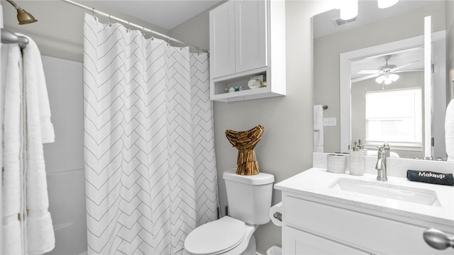 bathroom featuring toilet, vanity, ceiling fan, and curtained shower