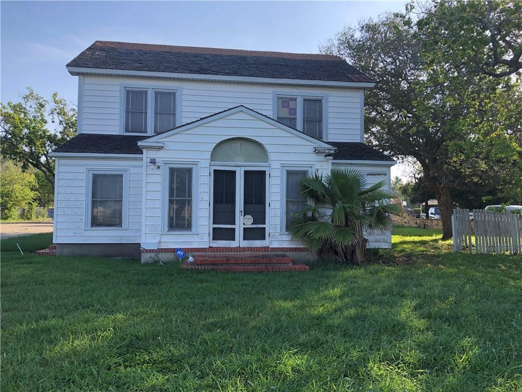 rear view of property with a yard