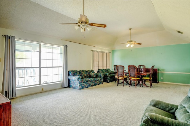 carpeted living area with vaulted ceiling, visible vents, a textured ceiling, and a ceiling fan