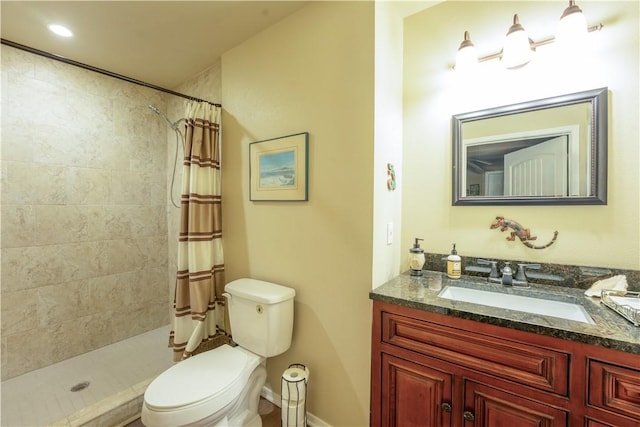 full bath featuring toilet, a tile shower, and vanity