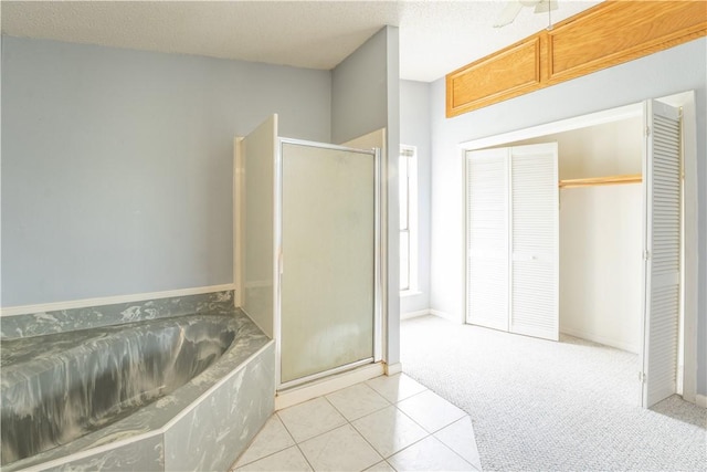 bathroom with a garden tub, a shower stall, a textured ceiling, and tile patterned floors