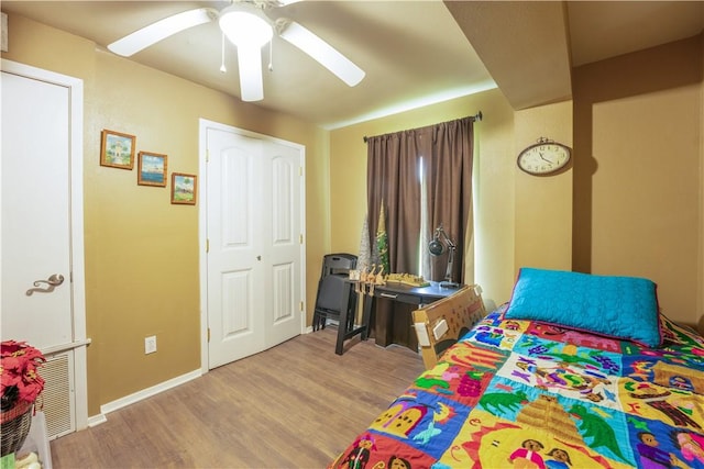 bedroom with ceiling fan, wood finished floors, visible vents, and baseboards