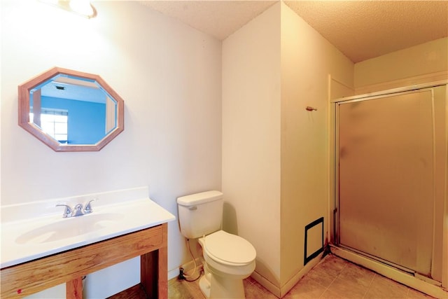 full bathroom featuring toilet, tile patterned floors, a textured ceiling, a shower stall, and a sink