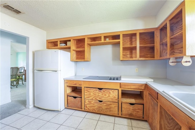 kitchen featuring black electric cooktop, visible vents, light countertops, freestanding refrigerator, and open shelves