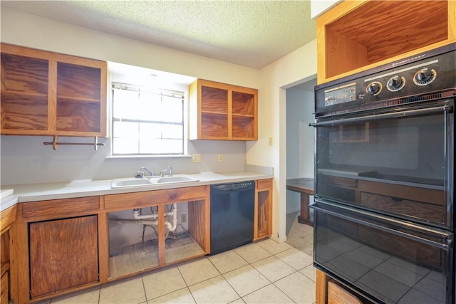 kitchen with a textured ceiling, black appliances, a sink, and light countertops