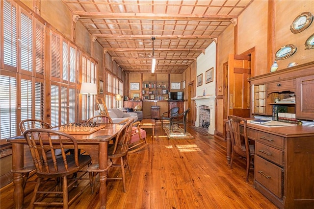 dining space featuring wooden ceiling, beamed ceiling, wood walls, brick ceiling, and hardwood / wood-style flooring