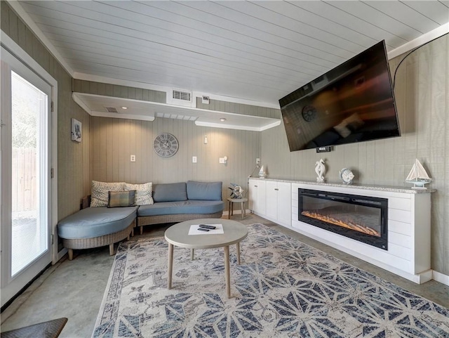 living room featuring a healthy amount of sunlight and wood walls