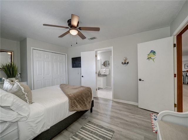 bedroom featuring ceiling fan, ensuite bath, a closet, and light wood-type flooring