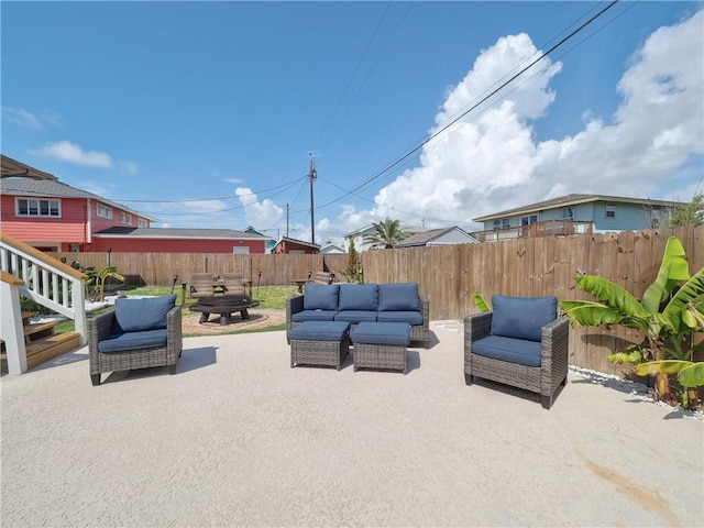 view of patio with an outdoor living space with a fire pit