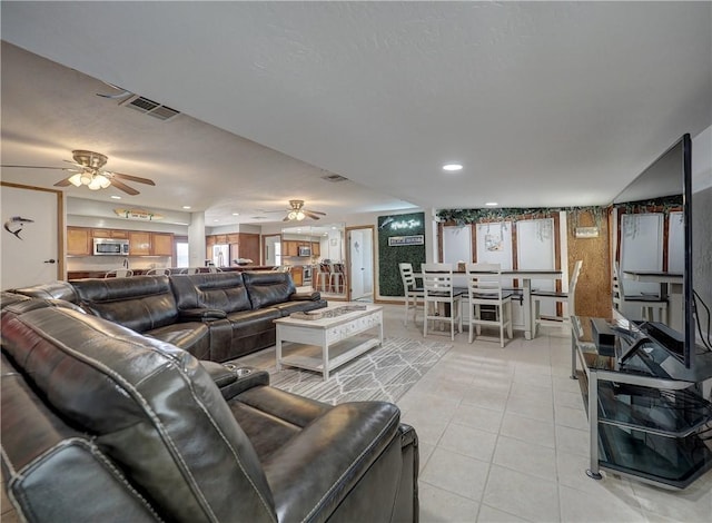 living room featuring light tile patterned floors and ceiling fan