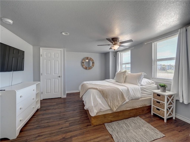 bedroom featuring ceiling fan, dark hardwood / wood-style floors, and a textured ceiling