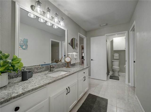 bathroom featuring tile patterned flooring, vanity, and toilet