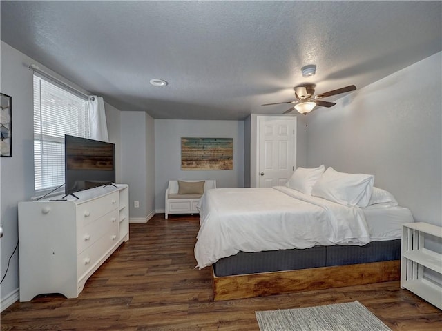 bedroom featuring ceiling fan, dark wood-type flooring, and a textured ceiling