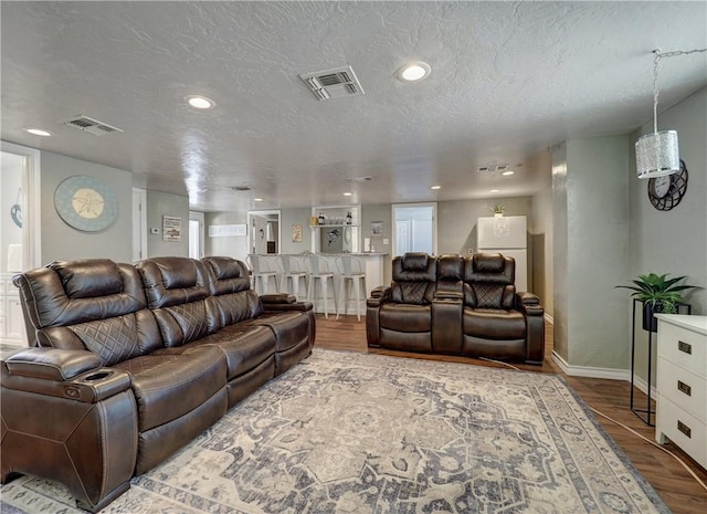 living room featuring hardwood / wood-style flooring and a textured ceiling