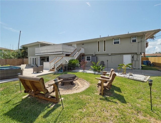 back of property with a yard, an outdoor living space with a fire pit, and a patio