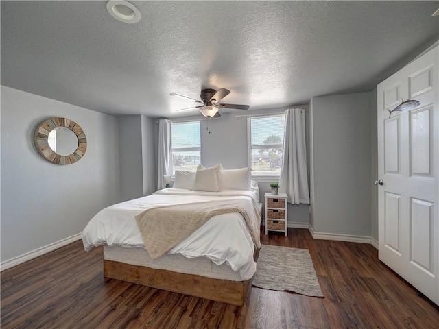 bedroom featuring dark hardwood / wood-style floors, a textured ceiling, and ceiling fan