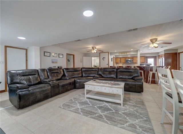 living room with light tile patterned floors and ceiling fan