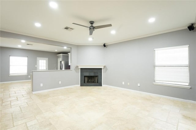 unfurnished living room with ceiling fan, ornamental molding, and a tile fireplace