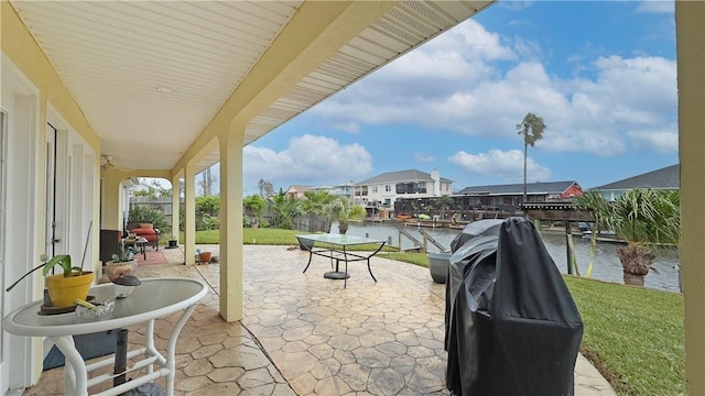 view of patio / terrace with a water view, a boat dock, and grilling area