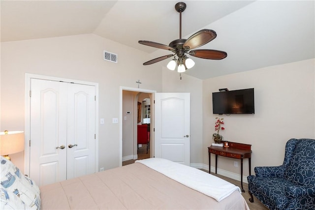 bedroom featuring ceiling fan, a closet, and lofted ceiling