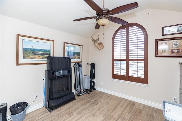 exercise room featuring lofted ceiling, ceiling fan, and light hardwood / wood-style flooring