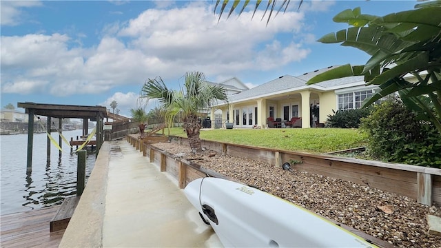 dock area with a lawn and a water view