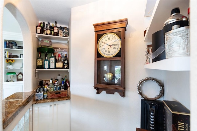 bar featuring white cabinets and dark stone countertops