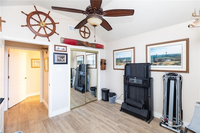 exercise room with lofted ceiling, ceiling fan, and light wood-type flooring