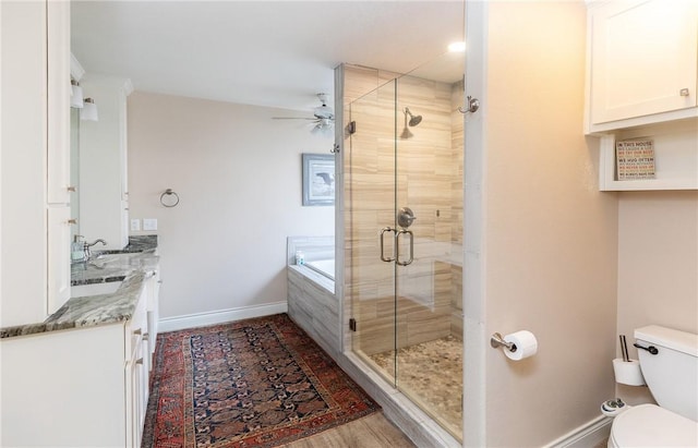 full bathroom with toilet, ceiling fan, wood-type flooring, shower with separate bathtub, and vanity