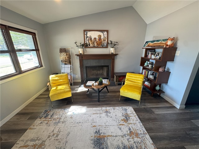 sitting room featuring lofted ceiling, dark wood-type flooring, and a tile fireplace